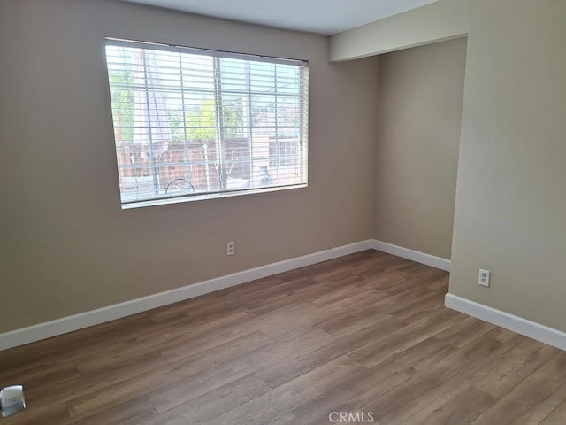 spare room with hardwood / wood-style floors and a healthy amount of sunlight