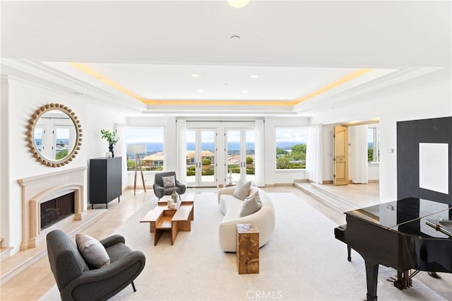 living room with crown molding, french doors, a fireplace, and a tray ceiling