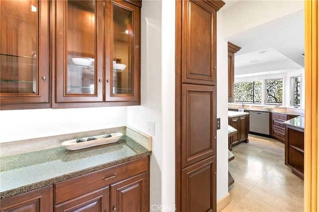 interior space with stone counters, a tray ceiling, and dishwasher