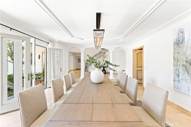 dining room featuring a chandelier, french doors, decorative columns, and crown molding