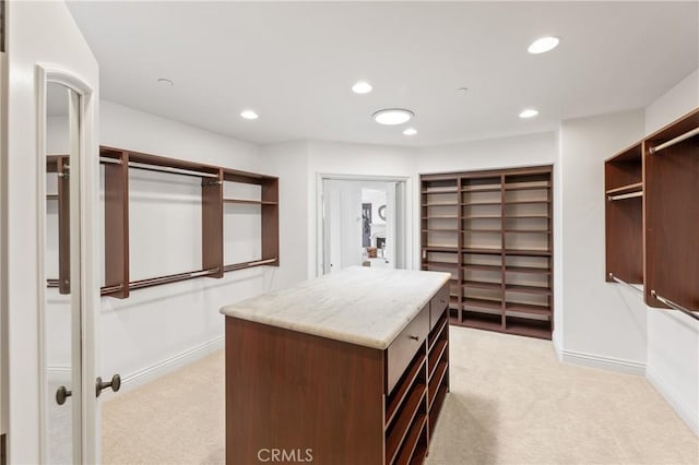 spacious closet featuring light colored carpet