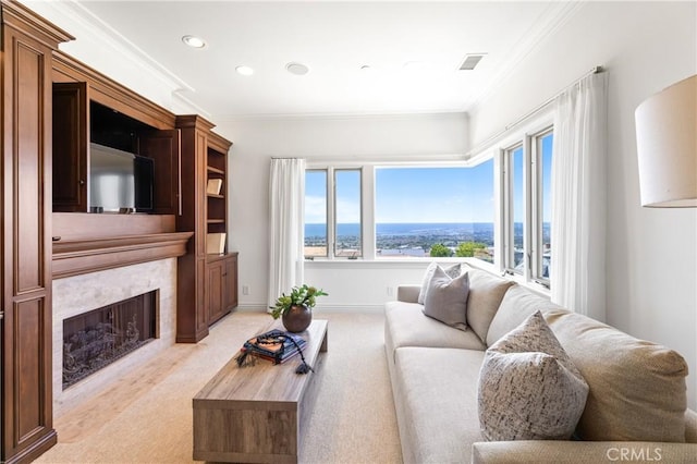 carpeted living room with a high end fireplace and ornamental molding