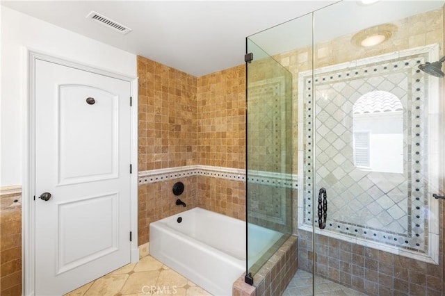 bathroom with separate shower and tub, tile patterned floors, and tile walls