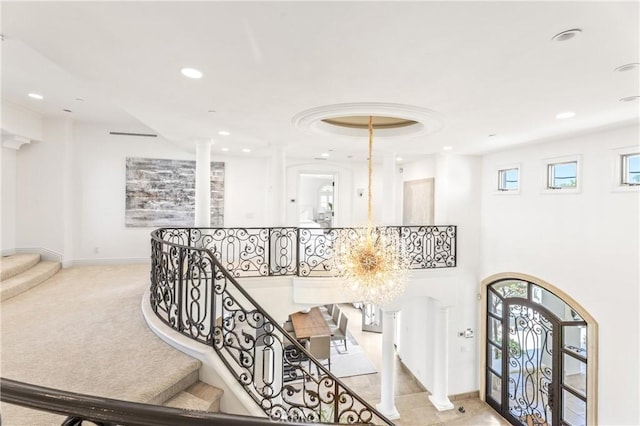 stairway with carpet and an inviting chandelier