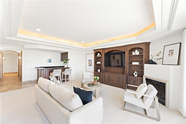 living room with a tray ceiling and light colored carpet