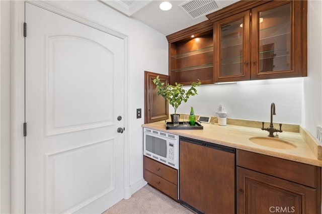 kitchen with light colored carpet, sink, and white microwave