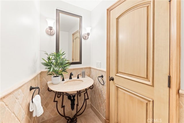 bathroom with sink and tile walls