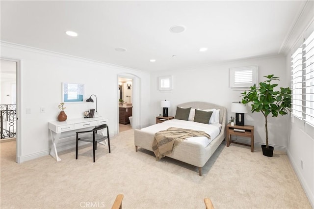 bedroom with crown molding, connected bathroom, and multiple windows