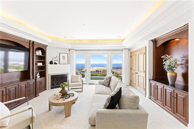 living room featuring light carpet and a tray ceiling