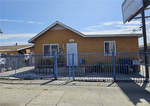 view of front of house featuring fence and stucco siding