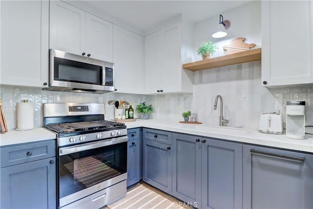 387 Cypress Dr Unit 7, Laguna Beach, CA 92651 - kitchen featuring appliances with stainless steel finishes, a sink, open shelves, white cabinets, and light countertops