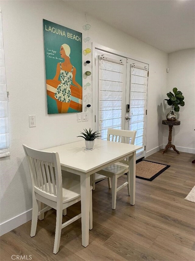 387 Cypress Dr Unit 7, Laguna Beach, CA 92651 - dining space featuring wood finished floors, baseboards, and french doors