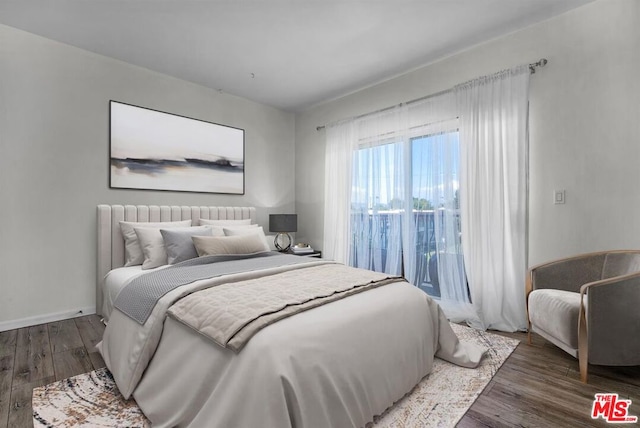 bedroom with dark wood-type flooring and access to exterior