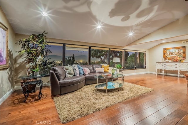 living room featuring light wood-type flooring and vaulted ceiling