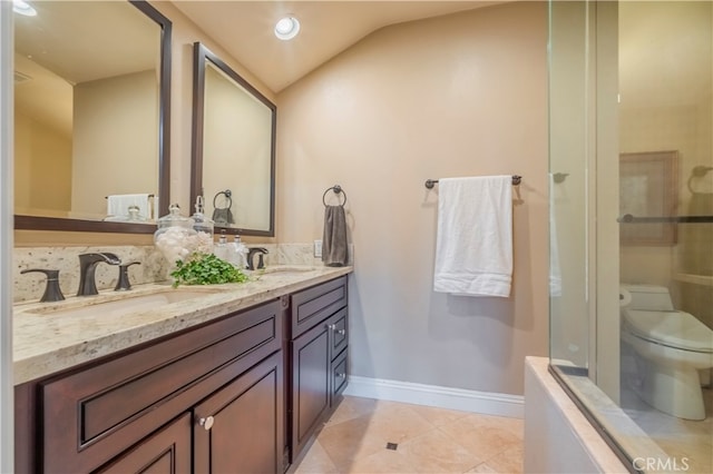 bathroom with vaulted ceiling, tile patterned floors, vanity, and toilet