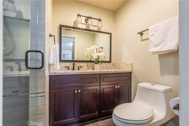 bathroom featuring vanity, tile patterned flooring, toilet, and an enclosed shower