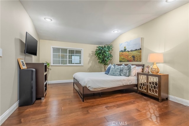 bedroom featuring wood-type flooring and vaulted ceiling