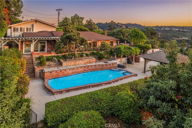 pool at dusk with a patio