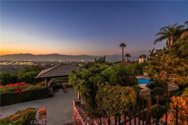 view of community featuring a gazebo, a mountain view, and a patio area