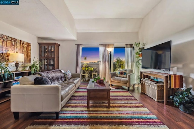 living room with dark wood-type flooring and vaulted ceiling