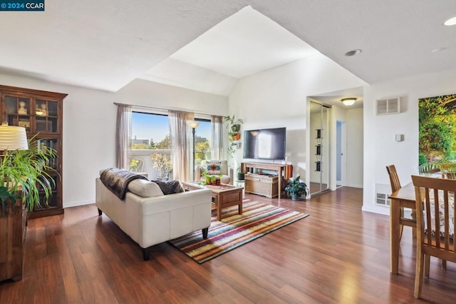 living room with lofted ceiling and dark hardwood / wood-style floors