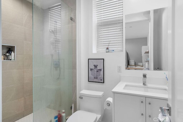 bathroom featuring vanity, toilet, and tiled shower