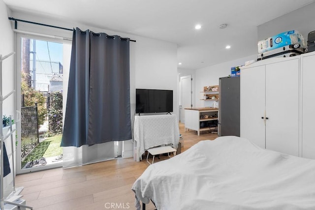 bedroom with access to outside, multiple windows, a closet, and light hardwood / wood-style floors