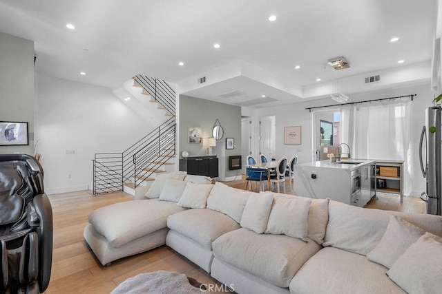 living room featuring light hardwood / wood-style flooring and sink