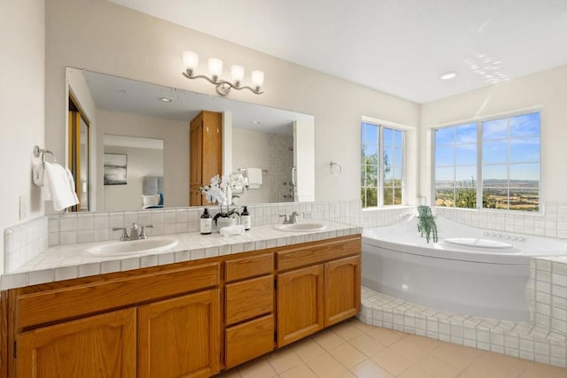 bathroom with a bath, vanity, tile patterned floors, and tasteful backsplash