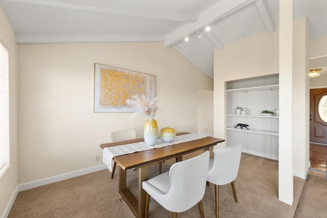 dining room with track lighting, vaulted ceiling with beams, and light colored carpet