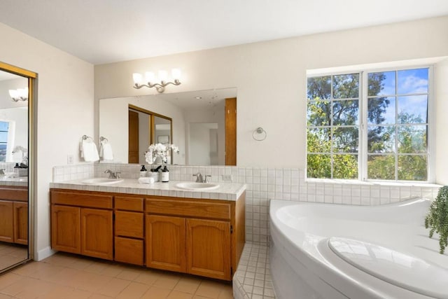 bathroom with vanity, a tub, and tile patterned floors