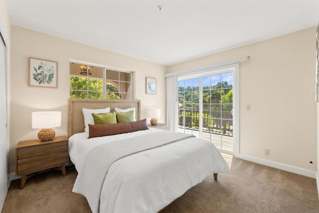 bedroom with multiple windows, carpet flooring, and access to exterior