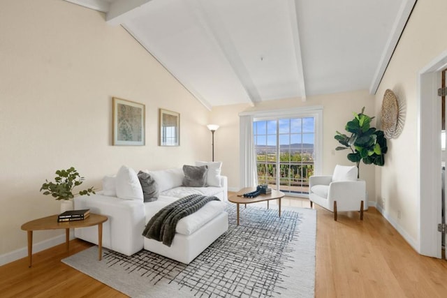 living room featuring light wood-type flooring and lofted ceiling with beams