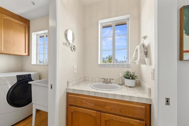 laundry area with washer / clothes dryer, cabinets, sink, and a healthy amount of sunlight