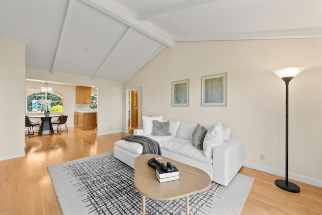 living room featuring lofted ceiling with beams, light hardwood / wood-style floors, and an inviting chandelier