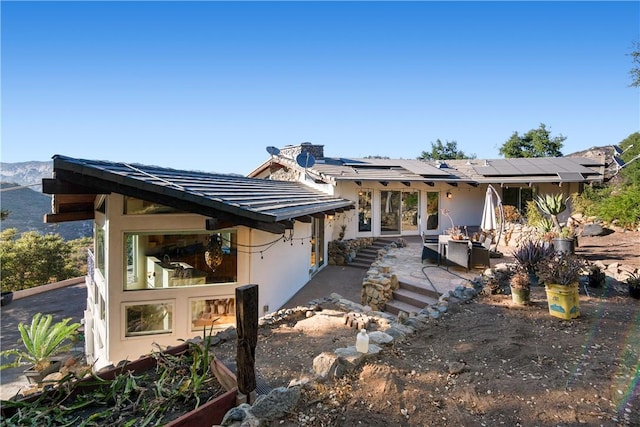 rear view of house with a mountain view and a patio