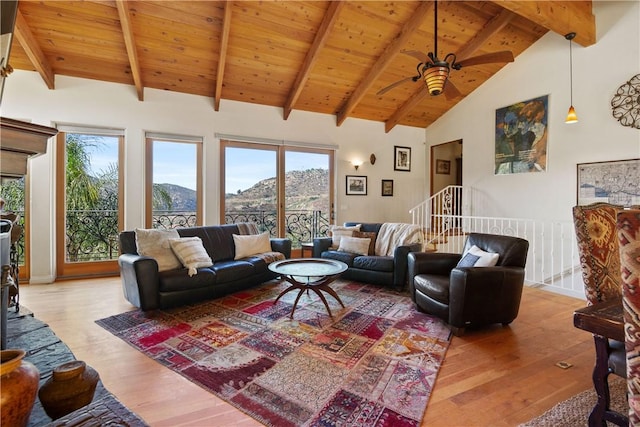 living room with beamed ceiling, a mountain view, ceiling fan, and light wood-type flooring