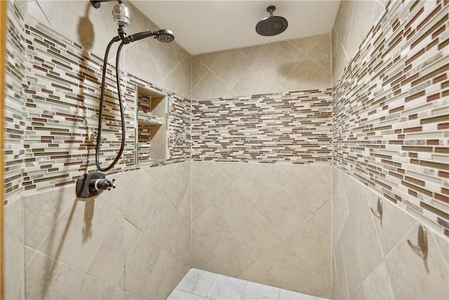 bathroom with a tile shower, backsplash, and tile walls