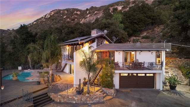 view of front facade with a mountain view, a balcony, and a garage