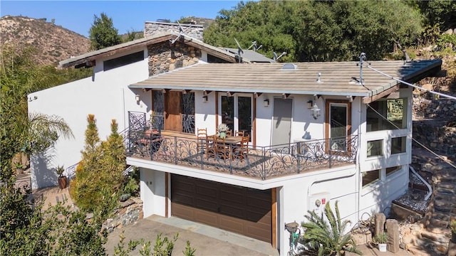 view of front facade featuring a mountain view, a balcony, and a garage