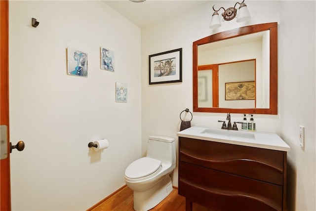 bathroom with wood-type flooring, vanity, and toilet