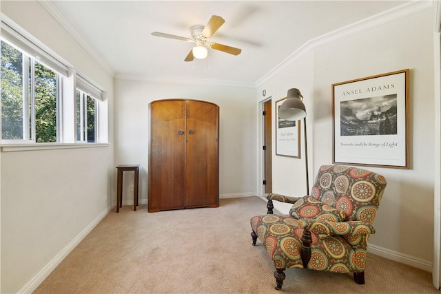 living area with light colored carpet, ceiling fan, and crown molding