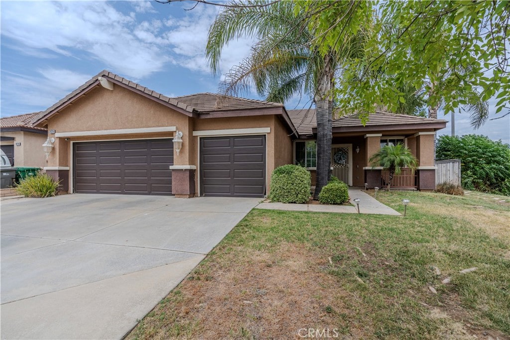 ranch-style house with a garage and a front lawn