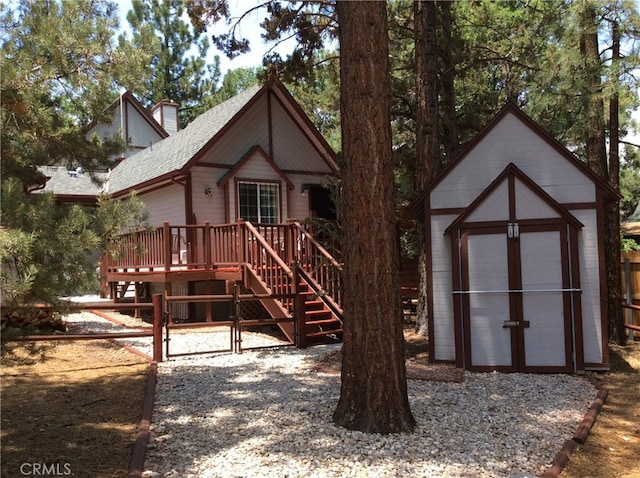 view of front facade with a shed and a wooden deck