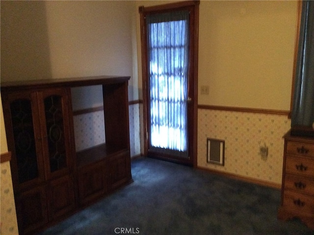 unfurnished living room with dark colored carpet