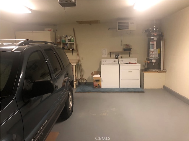 garage with gas water heater, a garage door opener, and washing machine and dryer