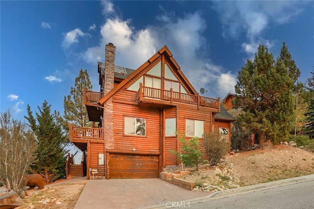 log cabin featuring a garage and a balcony