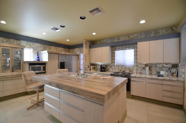 kitchen with gas stove, a center island, a wealth of natural light, and wooden counters