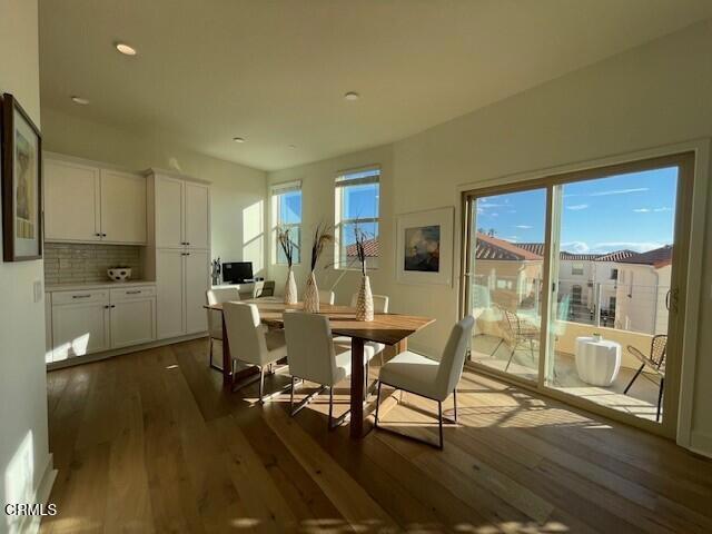 dining space with dark wood-type flooring, plenty of natural light, and recessed lighting