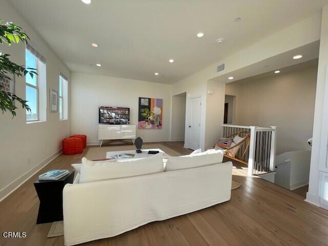 living room featuring recessed lighting, visible vents, baseboards, and wood finished floors